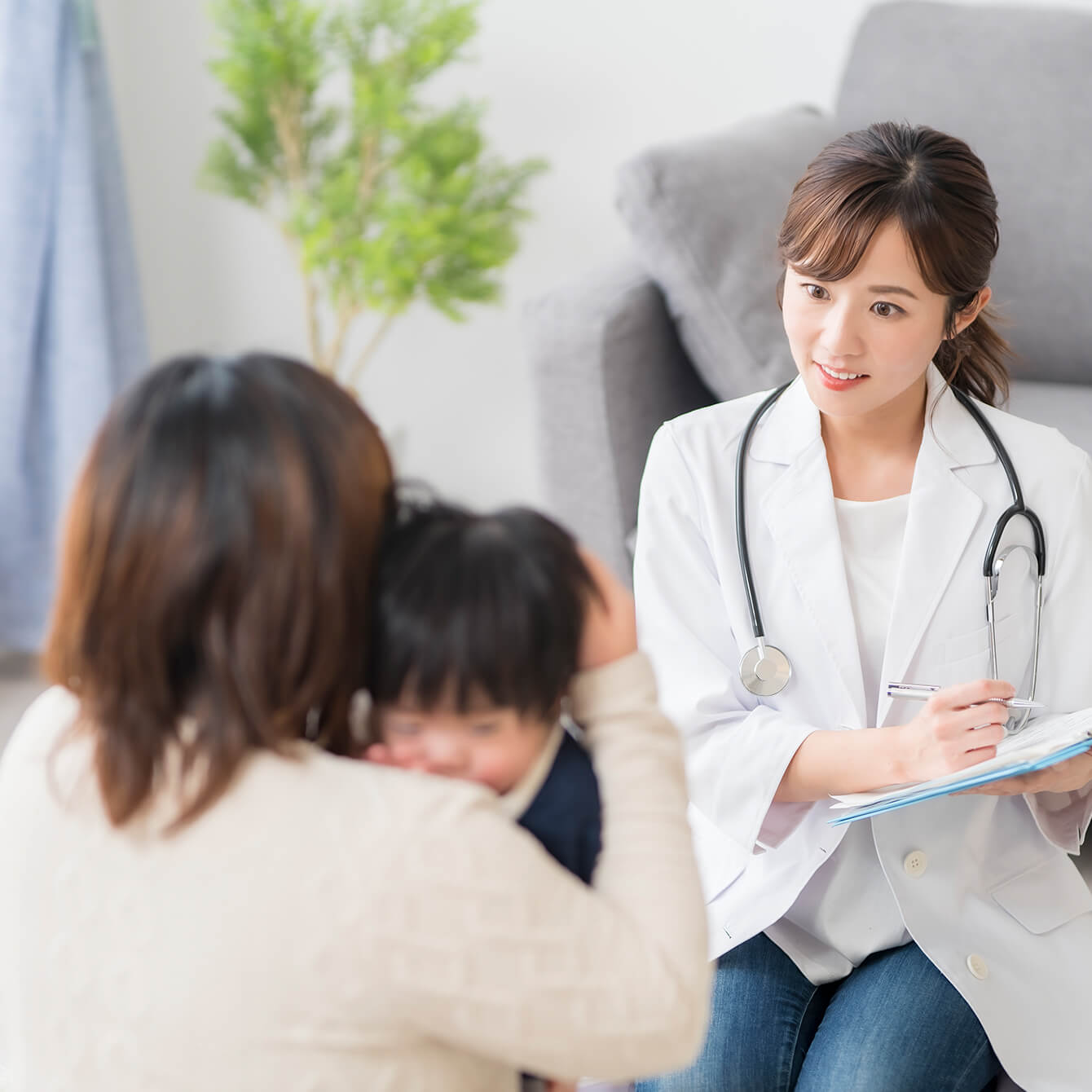 家庭に訪問して女の子の診療を行う女性医師